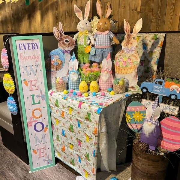 An Easter display with bunny decorations, gnomes, colorful eggs, and a "Welcome" sign.